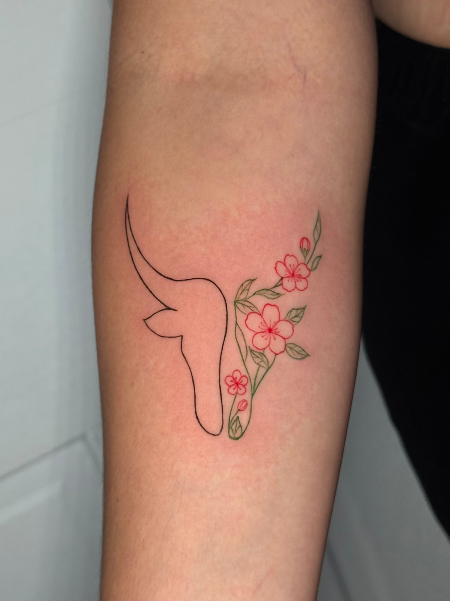 Fine line bull head and blossom tattoo by Karen