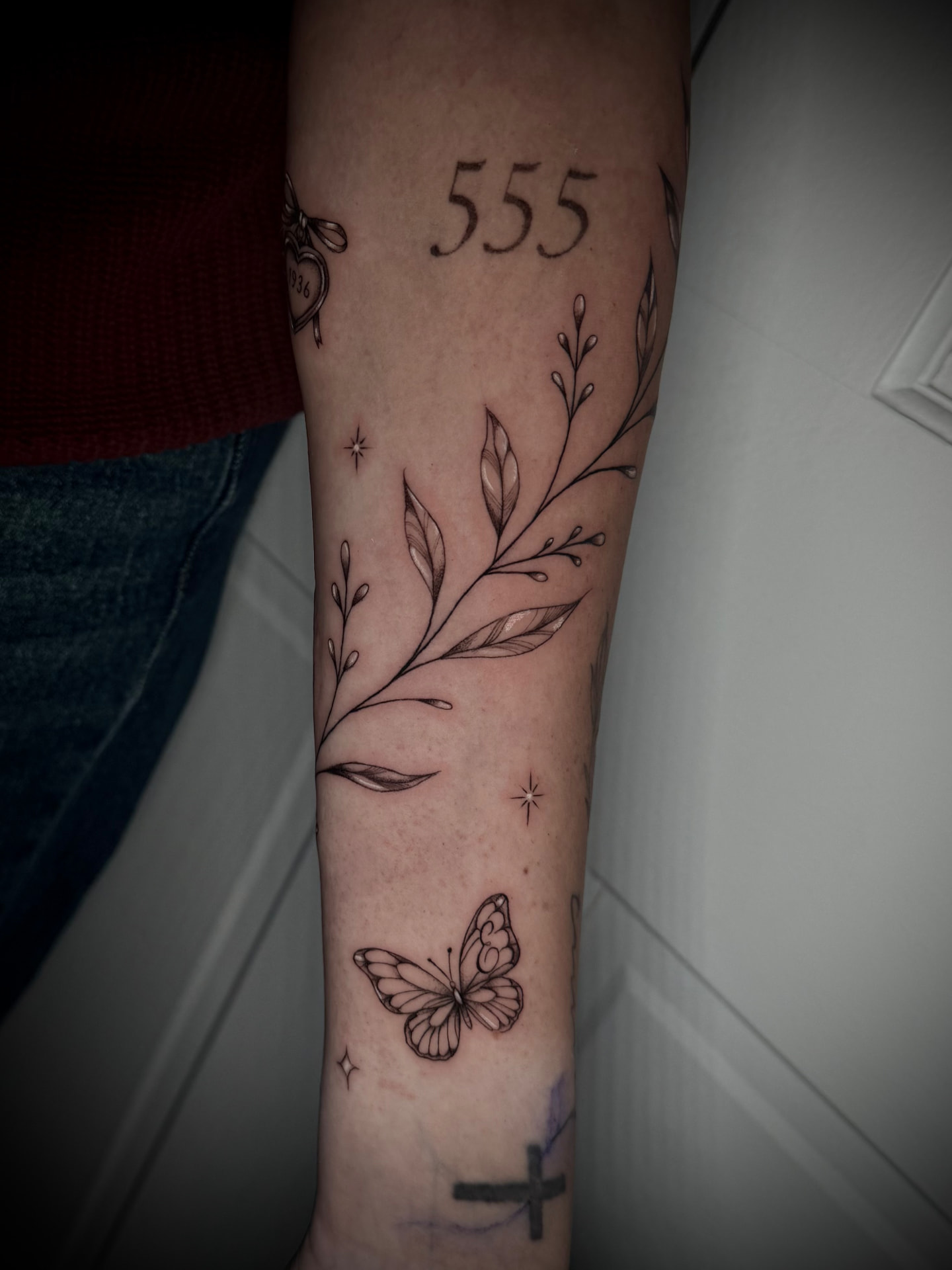 Fine line botanical branch and butterfly tattoo by Karen