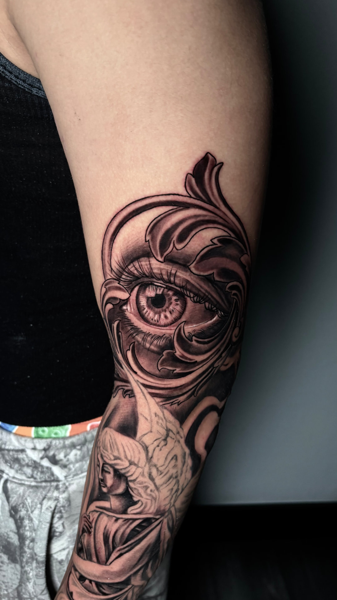 Black and grey eye and angel tattoo by Joey